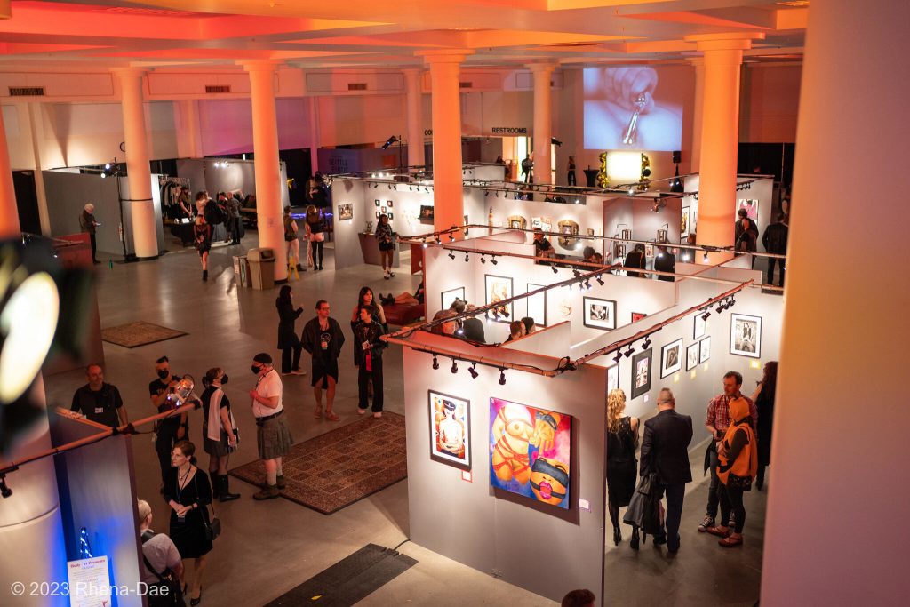 SEAF 2024 Award Winners: A picture of the Seattle Center Exhibition Hall taken from an elevated position, showing the art walls of the Seattle Erotic Art Festival and crowd viewing the art.